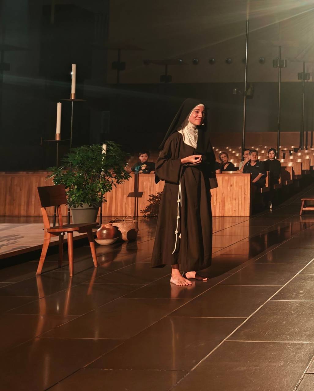 Sharda Harrison mezítláb, Szent Kláraként szólítja meg a közönséget a „TO GAZE: St. Clare of Assisi” első előadásán, 2026. október 16-án. | Fotó: Benedict Tang